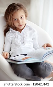 Portrait Of 6 Years Old Child Reading Book At Home