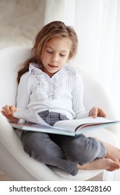 Portrait Of 6 Years Old Child Reading Book At Home