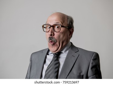 Portrait von 60ern kahler, glücklicher Geschäftsmann, der lustig und komisch in Lachen und lustigem Gesichtsausdruck schwingt und glücklich und fröhlich aussieht, einzeln auf grauem Hintergrund 