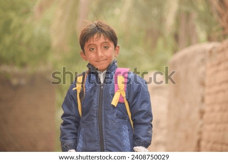 Portrait of 7 Year old boy student from Punjab Pakistan. Pakistani baby boy wearing school bag and ready to go to school. Education concept.Education in village of pakistan. Asian people from Pakistan