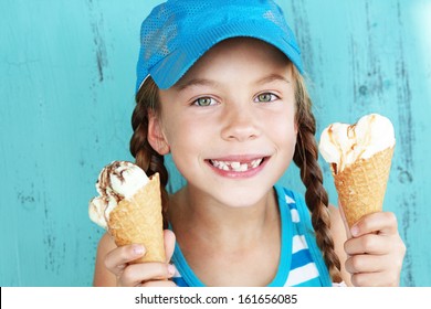 Portrait Of 7 Years Old Kid Girl Eating Tasty Ice Cream Over Blue