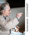 Portrait of an 86 yo grandmother eating fried donuts in Tienen, Flemish Brabant, Belgium