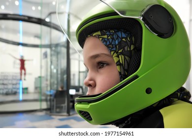 Portrait Of 8-year-old Boy In A Skydiving Helmet In Front Of Indoor Wind Tunnel.