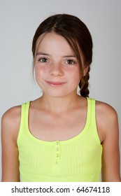 A portrait of a 9 (almost 10!) year old girl on a neutral background.  The girl has brown eyes and long brown hair.