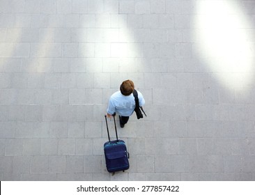 Portrait From Above Of A Young Man Walking With Luggage At Station