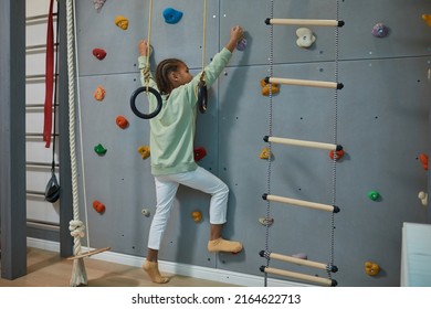 Portrait Of Active Black Child Climbing Wall On Home Sports Set, Copy Space