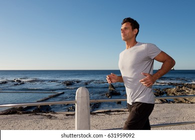 Portrait Of Active Middle Age Man Running Outside By Sea