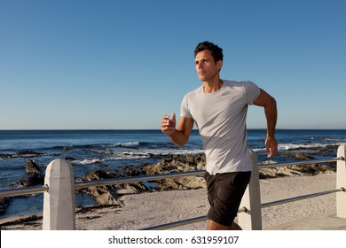 Portrait Of Active Middle Age Man Jogging Outside By Sea