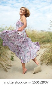 Portrait Of An Active Older Woman Dancing At The Beach