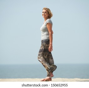 Portrait Of An Active Older Woman Walking At The Beach