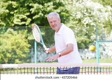 Portrait Of Active Senior Man Playing Tennis.