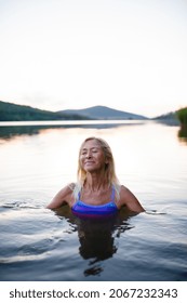 Portrait Of Active Senior Woman Swimmer Diving Outdoors In Lake.