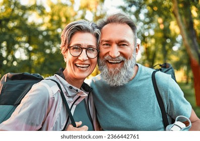 Portrait of active sincere carefree smiling happy modern gray haired couple shouldering bag with sport mats. Active old age, travel, hobbies, recreation, sports.Seniors activities. - Powered by Shutterstock