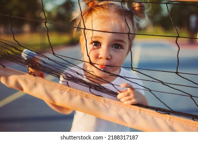 Portrait of adorable 2 years old girl eating ice cream outdoors, summer time. Conceptual active sweet kid on sports court