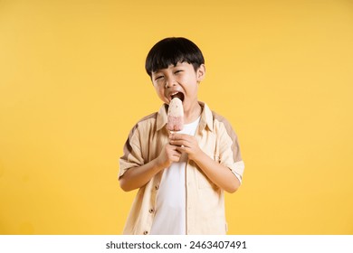 Portrait of adorable asian boy posing on yellow background - Powered by Shutterstock