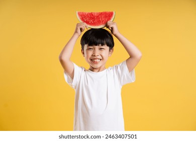 Portrait of adorable asian boy posing on yellow background - Powered by Shutterstock