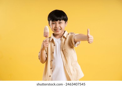 Portrait of adorable asian boy posing on yellow background - Powered by Shutterstock