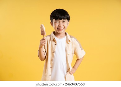 Portrait of adorable asian boy posing on yellow background - Powered by Shutterstock