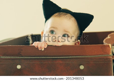 Portrait of adorable baby lying in vintage bag