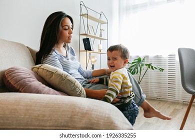 Portrait Of Adorable Little Boy On The Textile Couch With His Mom And Crying. Upset Toddler Throwing A Tantrum At Home. Barefoot Calling For Attention. Close Up, Copy Space, Background.