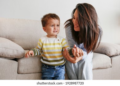 Portrait Of Adorable Little Boy Sitting On The Textile Couch With His Mom And Crying. Upset Toddler Throwing A Tantrum At Home. Barefoot Calling For Attention. Close Up, Copy Space, Background.