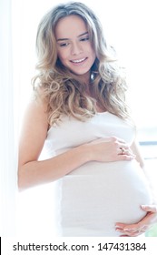Portrait of adorable pregnant woman in white - paradise