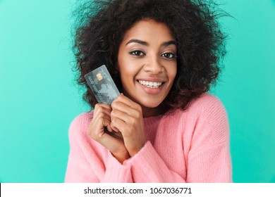 Portrait Of Adorable Woman With Shaggy Hair Holding Plastic Credit Card And Smiling Sincerely Isolated Over Blue Background