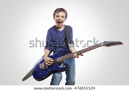Portrait of adorable young boy playing electric guitar. Rock and roll kid