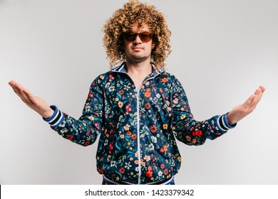 Portrait of adult amish male in clothes of 80s posing in studio with hands apart like  prophet of new religion. Odd man in sunglasses and calm face shows sign of god`s grace, humility, obedience