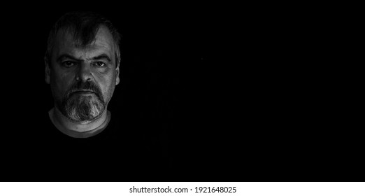 Retrato de hombre barbudo enojado adulto sobre fondo negro