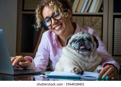 Portrait of adult cheerful young pretty woman and funny dog working together at laptop computer in home office room .- concept of people and online modern job activity