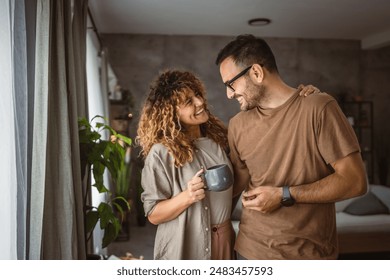 Portrait of adult couple wife and husband stand with coffee at home - Powered by Shutterstock