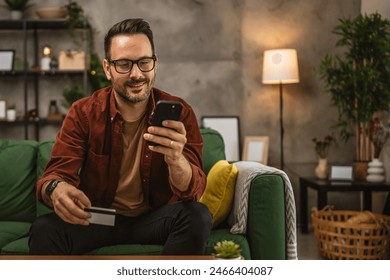 Portrait of adult man shop online with cellphone and hold credit card at home - Powered by Shutterstock