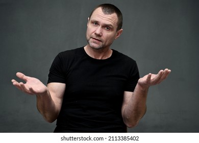 Portrait Of An Adult Man Talking Directly To The Camera On A Gray Background