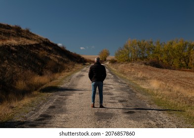 Portrait Of Adult Man In Winter Cloth On A Country Road Against Blue Sky. Shot In Castilla Y Leon, Spain