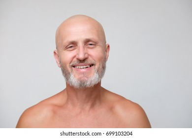 Portrait Of Adult Smiling Bearded Bold Skinhead Grizzled Man  On Gray