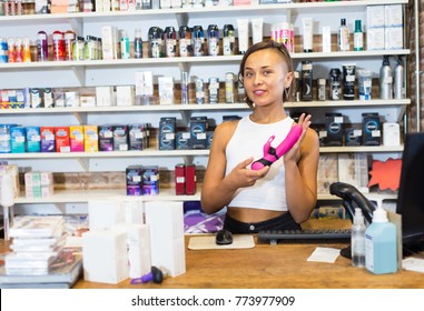 Portrait of adult woman assistant standing in the modern sex shop