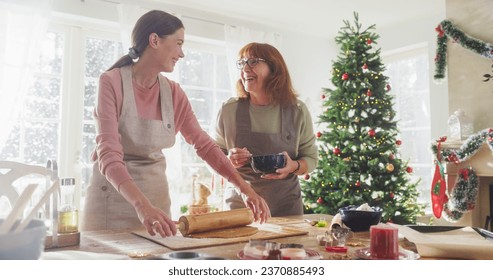 Portrait of Adult Woman Preparing Gingerbread for Christmas While her Senior Mother is Helping. Senior Woman and her Daughter in Law Making Pastries for Family and Friends - Powered by Shutterstock