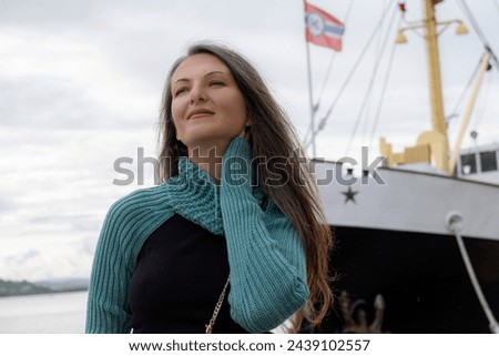 portrait of an adult woman smiling sweetly against the background of a yacht with a Norwegian flag. High quality photo