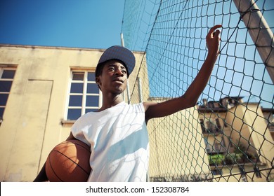 Portrait Of African American Boy With Basketball Looking Away