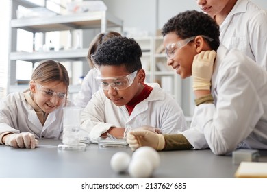 Portrait of African American boy enjoying enjoying science experiments in chemistry class and wearing protective gear - Powered by Shutterstock