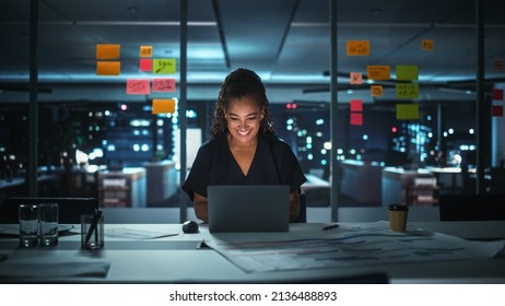 Portrait of African American Businesswoman Working on Laptop Computer in Big City Office Late in the Evening. Female Executive Director Managing Digital e-Commerce Project, Finance Analysis - Shutterstock ID 2136488893