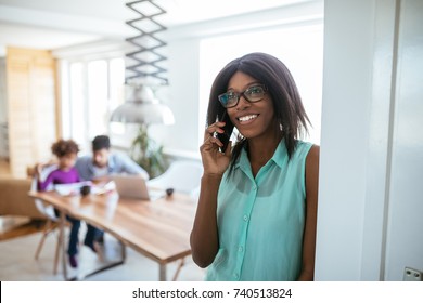 Portrait Of An African American Busy Mom Talking On The Phone.