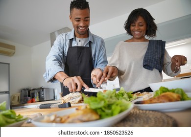 Portrait of african american couple having fun preparing meal together in home kitchen - Powered by Shutterstock