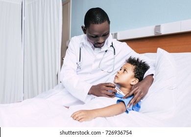 portrait of african american doctor measuring patients temperature in hospital