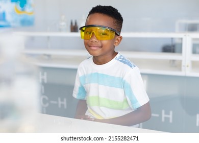 Portrait Of African American Elementary Schoolboy Wearing Protective Eyewear During Chemistry Class. Unaltered, Education, Laboratory, Stem, Scientific Experiment, Protection And School Concept.