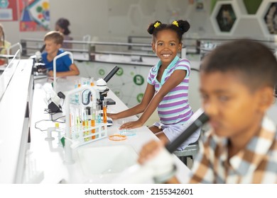 Portrait of african american elementary schoolgirl at desk in science laboratory. unaltered, education, childhood, learning, science, stem and school concept. - Powered by Shutterstock
