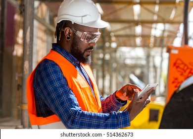 Portrait of African american engineer checking documents on tablet computer
