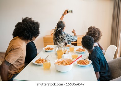 Portrait Of African American Family Having Lunch Together And Taking A Selfie With Phone At Home. Family And Lifestyle Concept.