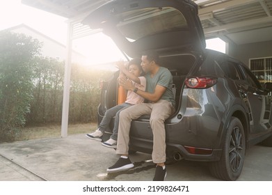 Portrait of African American Family waited sitting on the car trunk in front of house for their mother to prepare for holiday on a sunny day. Black Family enjoying road trip with their favorite car. - Powered by Shutterstock